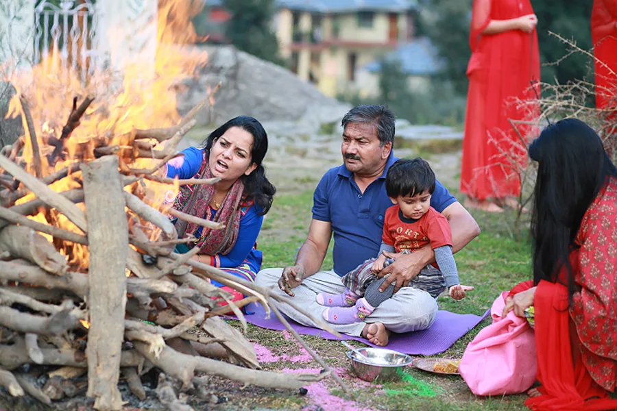 Guruji with a small child beside the fire at an earlier sadhana